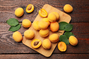Yummy ripe apricots on wooden table, flat lay