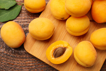 Yummy ripe apricots on wooden table, flat lay