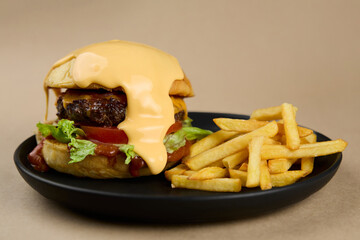Big cheese hamburger with French fries close up