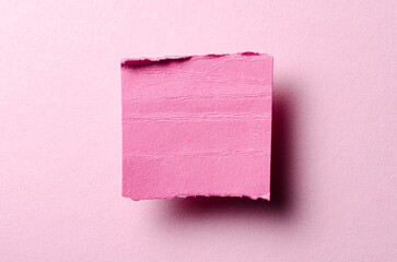 One single torn ripped wrinkled crumpled paper note with drop shadow, folded edge and copy space for text on pink background