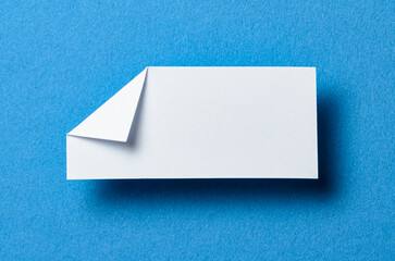 White blank paper note cardboard with folded corner dog-ear earmark, drop shadow and copy space for...