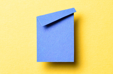 Blue blank paper note cardboard with folded corner dog-ear earmark, shadow and copy space for text...