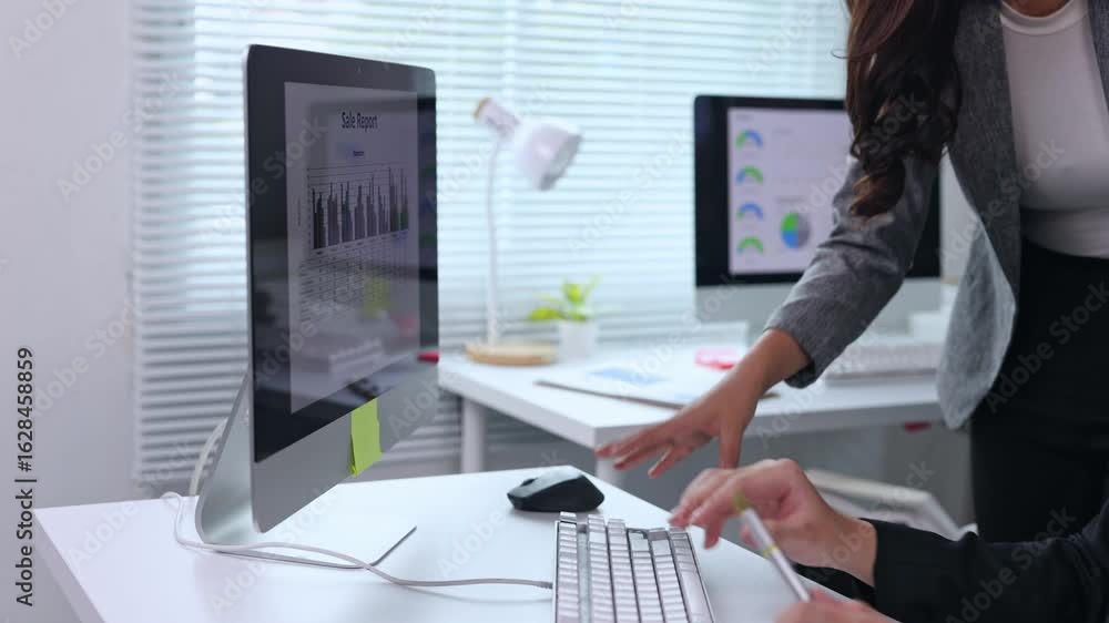 Poster business partners analyzing sales report data on computer screen, collaborating with professional fo