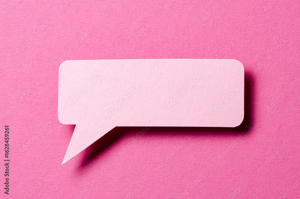 Poster paper speech bubble with shadow and copy space for text on pink background, close-up flat lay top vi