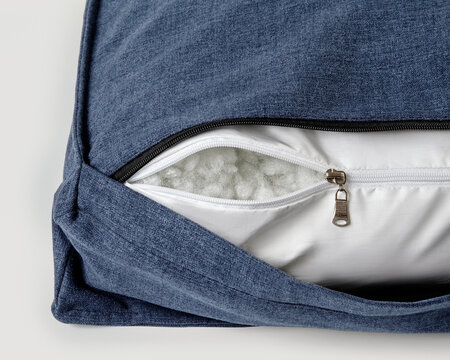 Open zipper showing cushion filling material on modern sofa