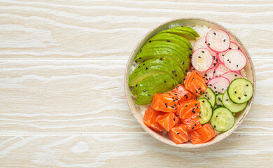 Poke bowl, a traditional hawaiian dish with diced raw salmon, avocado, vegetables served with rice...