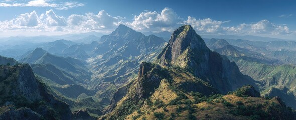 Panoramic view of a majestic mountain range under a partly cloudy sky; sunlit peaks and deep valleys create a dramatic landscape