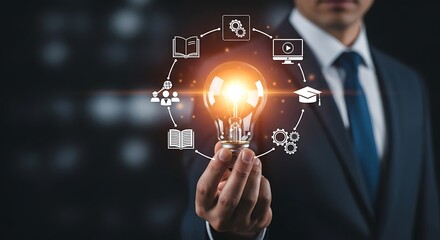 Businessman holding a glowing light bulb with education and technology icons in a circle idea