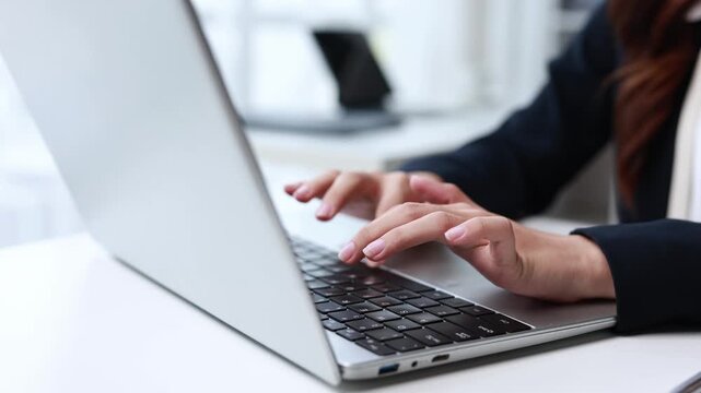 Professional female office worker rapidly typing on laptop keyboard. Capturing dynamic close up sequence showcasing productivity and workplace efficiency through precise. Focused computer interaction