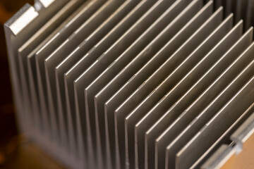 old grey aluminum radiator for cooling modern devices, part of an old used cooling system in the form of a metal alloy radiator, close up