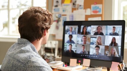 A man smiles while participating in a video conference with multiple participants displayed on his desktop monitor highlighting remote collaboration and online meetings - Powered by Adobe