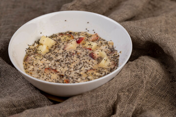oatmeal porridge with fruits and berries and lots of chia seeds, closeup