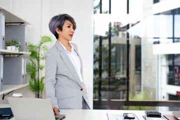 Happy dreamy mature senior business woman looking away at copy space and dreaming, planning....