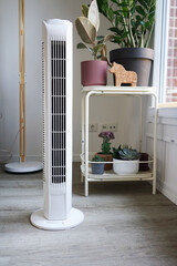 White tower fan against background of flowers in modern light interior