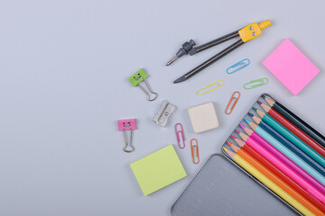Colorful school supplies arranged on a neutral gray surface.