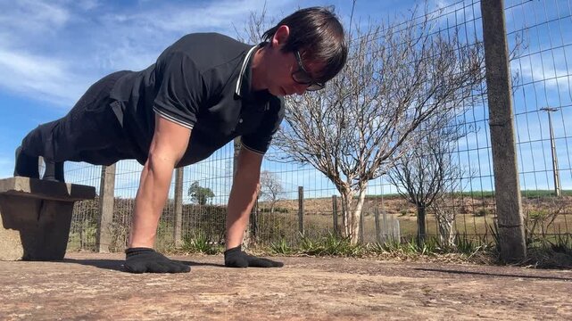 homem faz exerc&iacute;cios fis&iacute;cos ao ar livre 