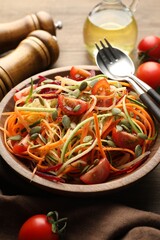 Tasty vegetable noodles served on wooden table, closeup