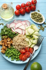 Different healthy vegetarian food served on light blue wooden table, flat lay