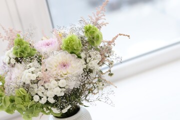 Bouquet of beautiful flowers on windowsill indoors, closeup. Space for text