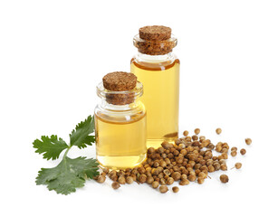 Aromatic oil in bottles, cilantro leaves and coriander seeds isolated on white