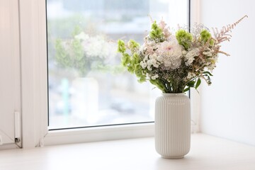 Bouquet of beautiful flowers on windowsill indoors, space for text