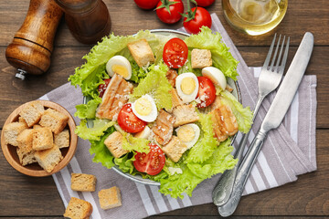 Delicious salad with croutons and ingredients on wooden table, flat lay