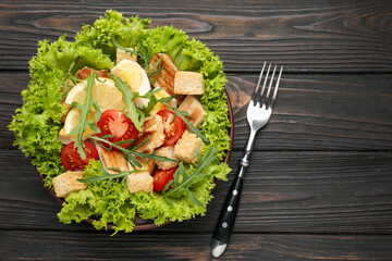 Delicious salad with croutons, chicken, egg, vegetables, lemon and arugula on wooden table, flat lay. Space for text