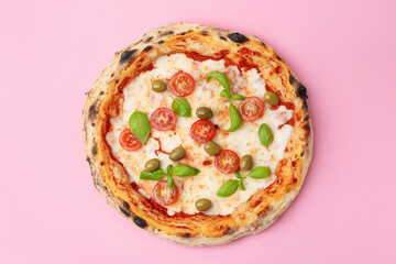 Delicious pizza with tomatoes, olives and basil on pink table, top view