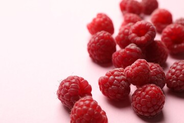 Tasty fresh ripe raspberries on pink background, closeup. Space for text
