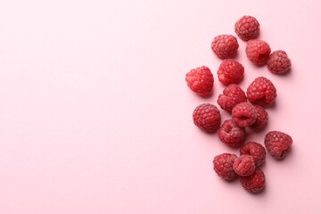 Tasty fresh ripe raspberries on pink background, flat lay. Space for text