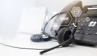 close up headset of call center and VOIP communication with futuristic virtual icon telecommunication technology on office table in monitoring room for network operation job concept