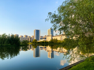 Cityscape with high rise buildings reflected in calm water surface in Minsk, Belarus.
