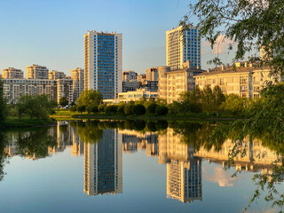 Cityscape with high rise buildings reflected in calm water surface in Minsk, Belarus.