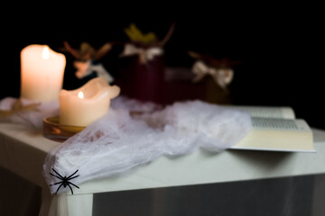 Halloween still life with candles, spider web and open book