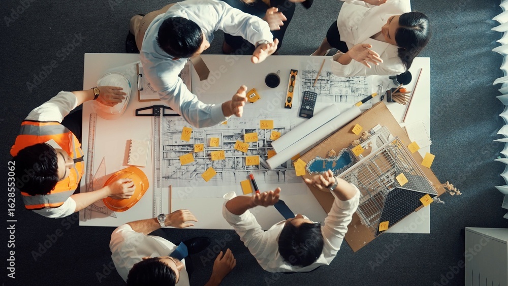 Poster top down view of smart engineer team talking while measuring house model. aerial view of group of in