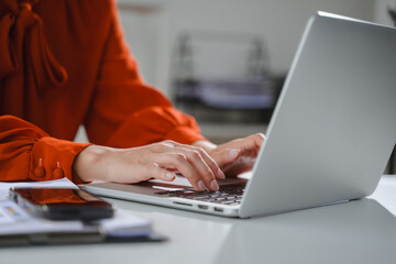 Businesswoman typing on laptop keyboard working at office desk