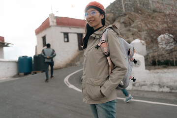 smiling Asian woman enjoys her travel adventure, radiating joy and warmth as sunlight illuminates her face, beautiful moment of happiness captured during an unforgettable journey