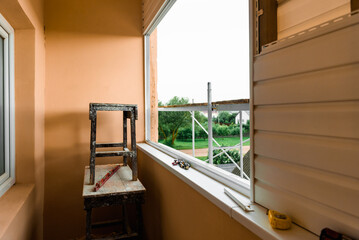 Installation of siding on the walls around the balcony window.