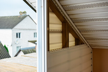 Installation of siding on the walls around the balcony window.
