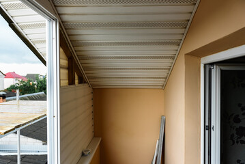 Installation of siding on the walls around the balcony window.