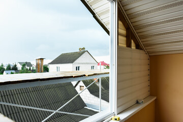 Installation of siding on the walls around the balcony window.