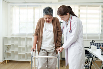 Orthopedist assists elderly Asian woman in completing a gait test, demonstrating discomfort while using crutches during rehabilitation, emphasizing pain and commitment to recovery from joint problems.