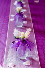 White roses decorating wedding table with purple runner