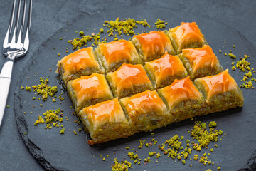 Turkish dessert pistachio baklava on black background. Special mini baklava