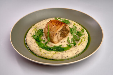 A Gourmet Dish Featuring Tender Chicken Breast Resting on Creamy Puree with Fresh Greens and a Drizzle of Olive Oil for an Elegant Presentation