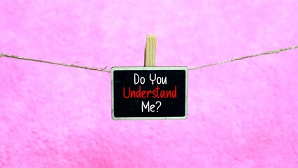 "Do You Understand Me?" question written on a small chalkboard hanging on a string with pink background.