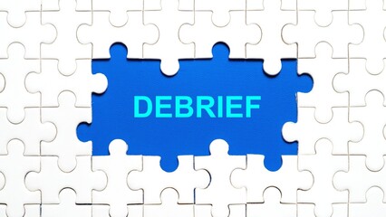 Conceptual image of a missing puzzle piece showing the text 'DEBRIEF' on a blue background.