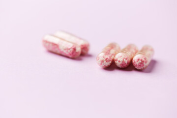 Vitamin B12 (also known as cobalamin) capsules on bright paper background. Soft focus. Close up. Copy space.	