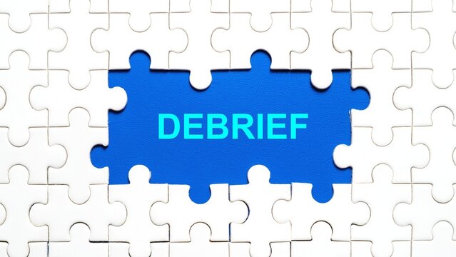 Conceptual image of a missing puzzle piece showing the text 'DEBRIEF' on a blue background.