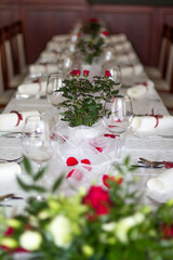 Wedding table setting decorated with red roses and white flowers